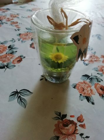 candela con dentro una margherita