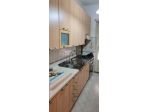 cucina con macchina a gas e tavolo con sedie