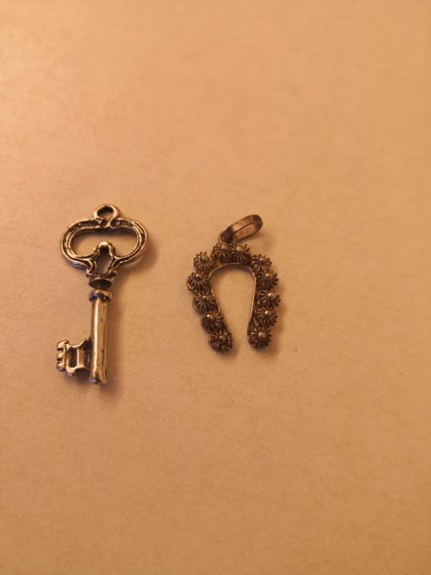 pendenti (2 pz) in argento, 1 chiave cm. 3 e 1 ferro di cavallo cm. 2, anni '80