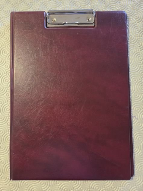 Porta Block Notes chiuso, in vera pelle marron scuro con fermaglio in acciaio.