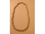 Collana girocollo con perle di bigiotteria con fermaglio.